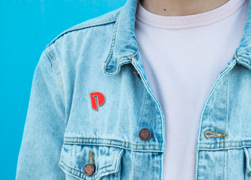 A photo of a person wearing a jacket with a planned parenthood pin on. 