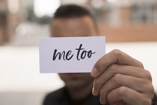 Person holding a card that says "me too"